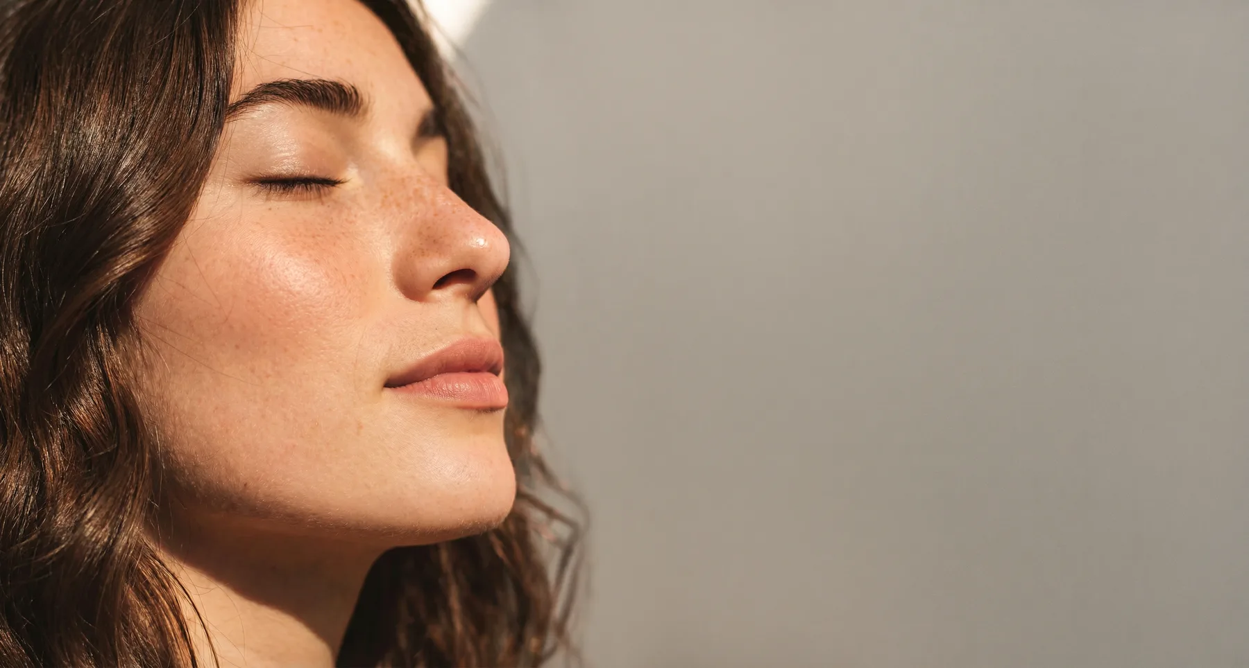 Woman with glowing skin and closed eyes
